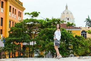 lindo mulher em branco vestir caminhando sozinho às a paredes em torno da a colonial cidade do cartagena de índias foto