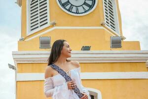 lindo mulher caminhando por aí cartagena de índias Próximo para a famoso relógio torre foto