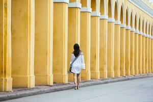 lindo mulher caminhando por aí a murado cidade dentro cartagena de índias foto