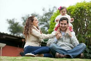 jovem pais tendo Diversão ao ar livre com seus 1 ano velho bebê garota. felicidade conceito. família conceito foto