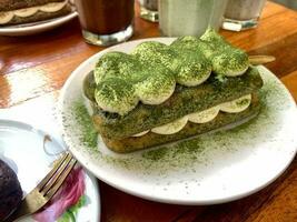 Tiramisu, italiano em camadas sobremesa com mascarpone creme, enfeitado com chá verde pó. foto