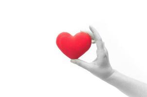 mão de mulher segurando coração vermelho em branco isolado no fundo branco, símbolo de amor ou namoro foto