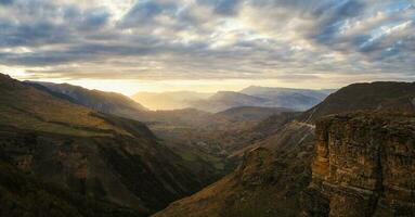 dourado pôr do sol dentro montanha panorama. silhueta do a tarde montanhas. foto