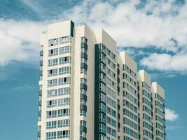 moderno lindo Novo arranha-céus residencial prédio. colori parede em a fundo do azul céu. cópia de espaço. foto