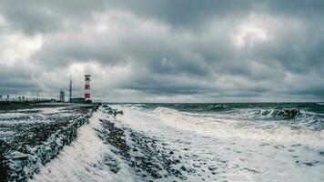 farol em a costa do a enfurecido branco mar em a cola Península. foto