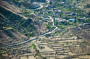 montanha Vila dentro daguestão. uma estrada através a vale. aéreo Visão foto