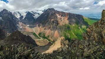 pitoresco montanha vale. perigoso couloir. colorida ensolarado verde panorama com silhuetas do grande rochoso montanhas e épico profundo desfiladeiro. foto