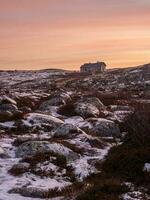 tarde polar panorama com a velho dilapidado casa em uma rochoso costa. foto