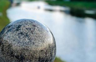 grande bola decorativa de mármore contra o fundo do rio foto