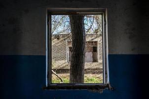 vista da janela de uma casa abandonada abandonada na ucrânia foto