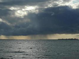 enorme nuvem negra despeja chuva no mar foto