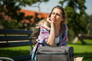 frustrado jovem turista mulher sentado em a parque foto