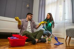 jovem casal é limpeza seus apartamento foto