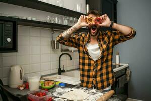 uma homem cozimento biscoitos dentro a cozinha foto