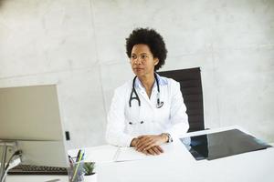 médico sentado em uma mesa olhando para longe foto