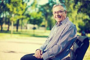 retrato do uma Senior homem em a parque foto