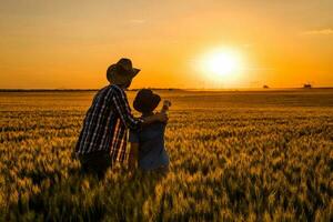 pai e filho em pé dentro uma trigo campo foto