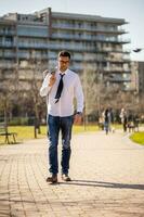 uma homem de negocios caminhando dentro a parque foto