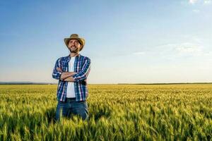 agricultor em pé dentro uma trigo campo foto