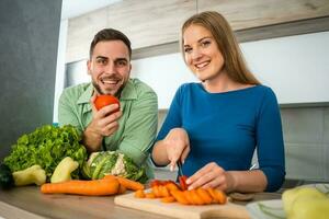 uma jovem casal cozinhando juntos foto