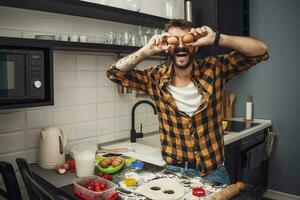 uma homem cozimento biscoitos dentro a cozinha foto