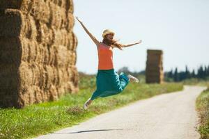 uma mulher em a estrada pulando foto