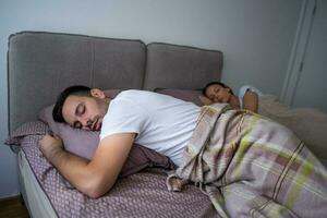 uma jovem casal deitado dentro cama foto