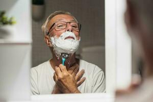 Senior homem faz a barba dele barba foto