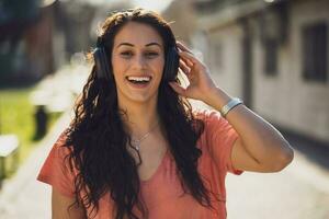 uma feliz jovem mulher ouvindo para música foto