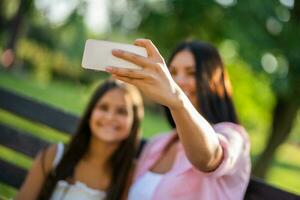 mãe e filha levando uma selfie às a parque foto