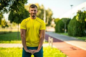 uma homem dentro uma amarelo camiseta fazendo fisica exercícios foto