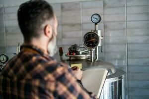 uma cervejaria mestre supervisionar a Cerveja Produção processo foto