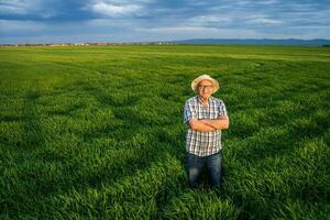 uma agricultor em pé dentro uma cevada campo foto