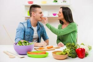 uma casal tendo Diversão fazer uma salada foto