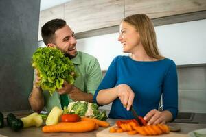 uma jovem casal cozinhando juntos foto