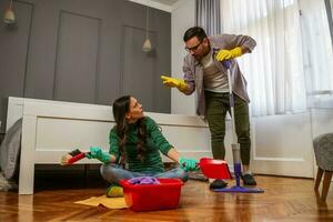 jovem casal é limpeza seus apartamento foto