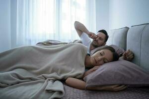 uma jovem casal deitado dentro cama foto