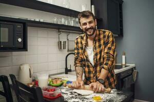 uma homem cozimento biscoitos dentro a cozinha foto