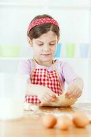 uma jovem menina cozinhando foto