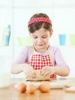 uma jovem menina cozinhando foto