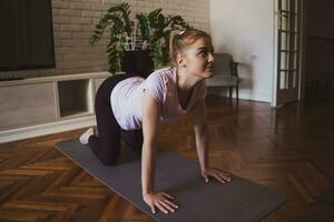 jovem mulher praticando pilates e ioga exercícios às casa foto