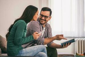 uma casal gastos Tempo juntos lendo uma livro foto