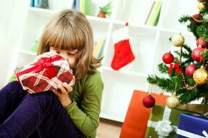 uma jovem menina abertura uma Natal presente foto