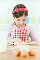 uma jovem menina cozinhando foto