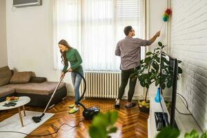 jovem casal é limpeza seus apartamento foto