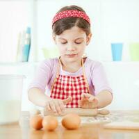 uma jovem menina cozinhando foto