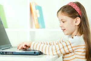 uma menina usando uma computador portátil foto