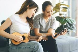 sudeste ásia pessoas casal relaxar estilo de vida jogando música em sofá vida momentos às casa foto