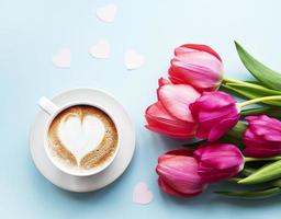xícara de café com latte art e tulipas