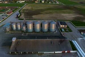 aéreo panorâmico Visão em agroindustrial complexo com silos e grão secagem linha para secagem limpeza e armazenamento do cereal cultivo foto